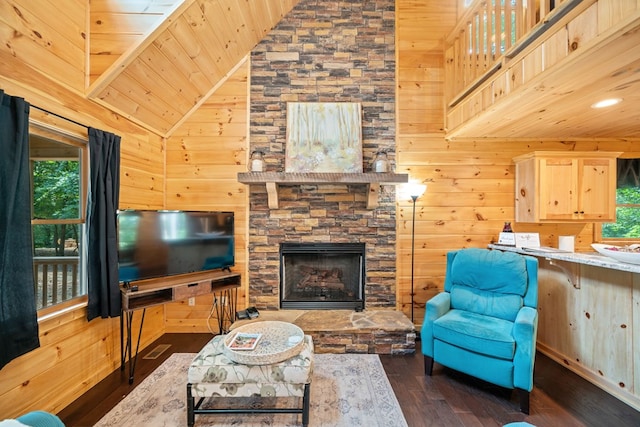 living room featuring dark hardwood / wood-style flooring, plenty of natural light, a fireplace, and wooden walls