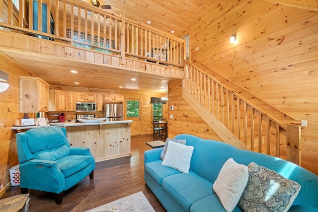 living room featuring dark hardwood / wood-style flooring, a towering ceiling, wooden ceiling, and wood walls