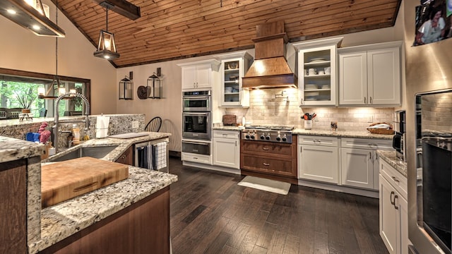 kitchen featuring wood ceiling, a sink, premium range hood, a warming drawer, and tasteful backsplash