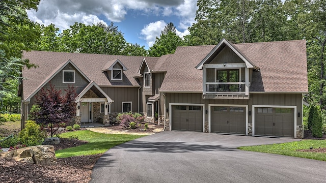 craftsman-style house with aphalt driveway, a garage, a shingled roof, and stone siding