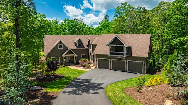 craftsman-style home with an attached garage, stone siding, driveway, board and batten siding, and a shingled roof