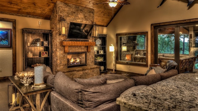 living area featuring a ceiling fan, high vaulted ceiling, baseboards, a stone fireplace, and wooden ceiling