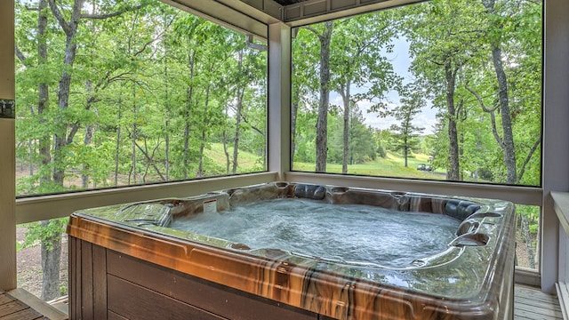 sunroom featuring a wealth of natural light, a jacuzzi, and baseboard heating