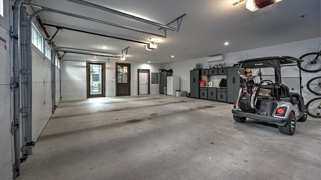 garage featuring a wall unit AC and a garage door opener