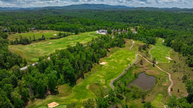 birds eye view of property with golf course view, a view of trees, and a water and mountain view