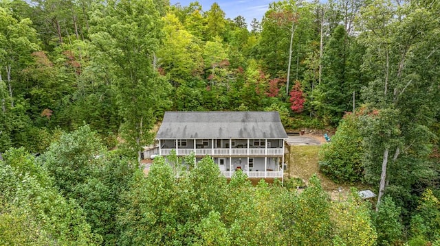 aerial view of property and surrounding area featuring a heavily wooded area