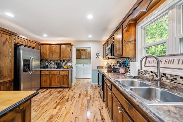 kitchen featuring stainless steel appliances, a sink, separate washer and dryer, tasteful backsplash, and recessed lighting