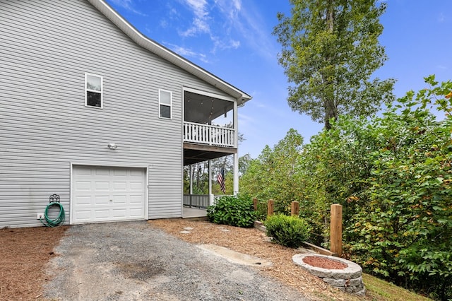 back of property featuring an attached garage and asphalt driveway