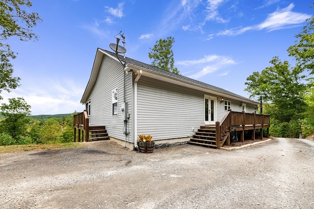 view of property exterior featuring a wooden deck and french doors
