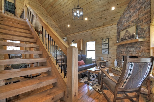 living room featuring dark hardwood / wood-style floors, high vaulted ceiling, wood walls, a notable chandelier, and wooden ceiling