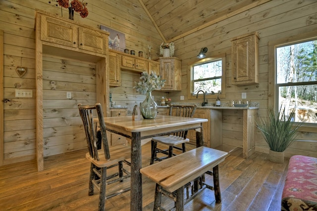 dining area featuring lofted ceiling, wooden walls, wooden ceiling, and wood-type flooring