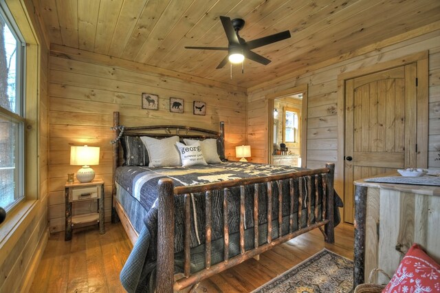 bedroom with wood ceiling, hardwood / wood-style floors, and wood walls