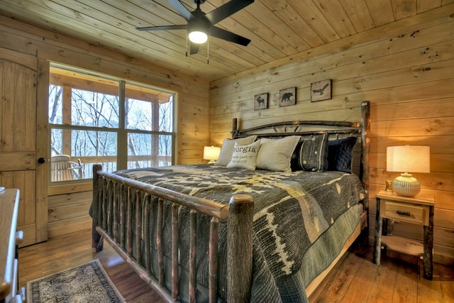 bedroom with hardwood / wood-style flooring, wood ceiling, and wooden walls