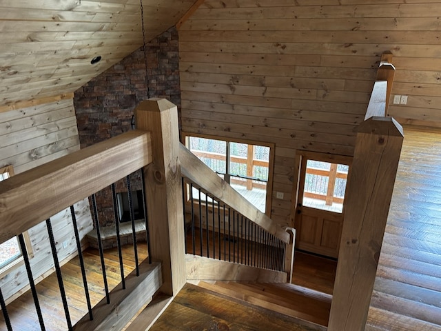 staircase featuring wooden ceiling, wood-type flooring, vaulted ceiling, and wood walls