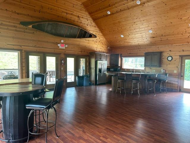 405 Lola Dr, Blairsville, GA 30512 - dining room featuring high vaulted ceiling, wood ceiling, wooden walls, and dark wood-style flooring
