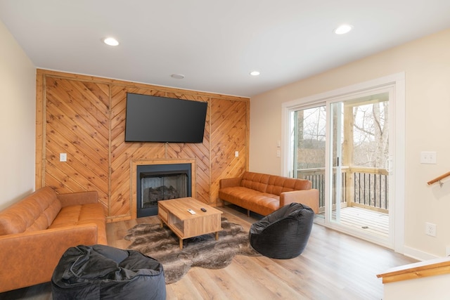 living room featuring wood finished floors, a fireplace, baseboards, and recessed lighting