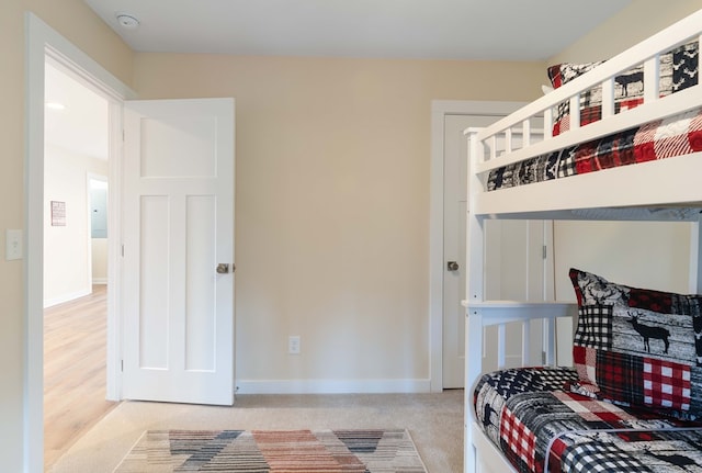 bedroom with baseboards and carpet