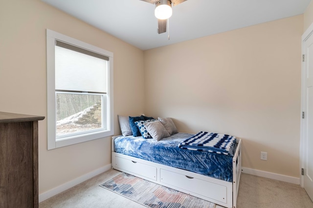 carpeted bedroom featuring baseboards and a ceiling fan