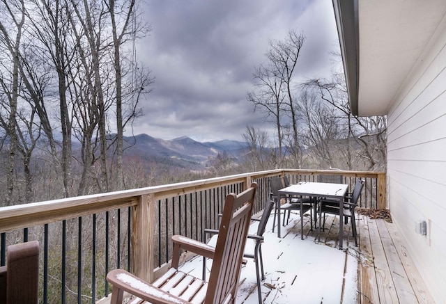 deck with a mountain view and outdoor dining space