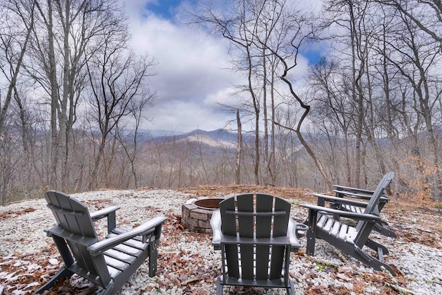view of yard featuring a fire pit, a view of trees, and a mountain view