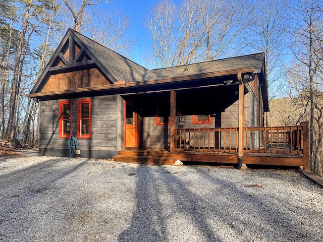 rustic home featuring a porch and roof with shingles