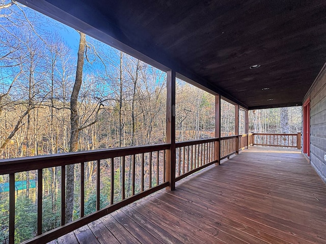 deck featuring a porch and a view of trees