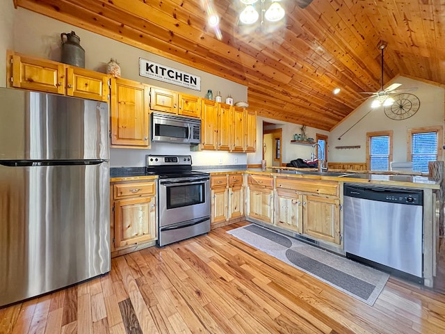 kitchen with a sink, vaulted ceiling, wood ceiling, light wood-style floors, and appliances with stainless steel finishes