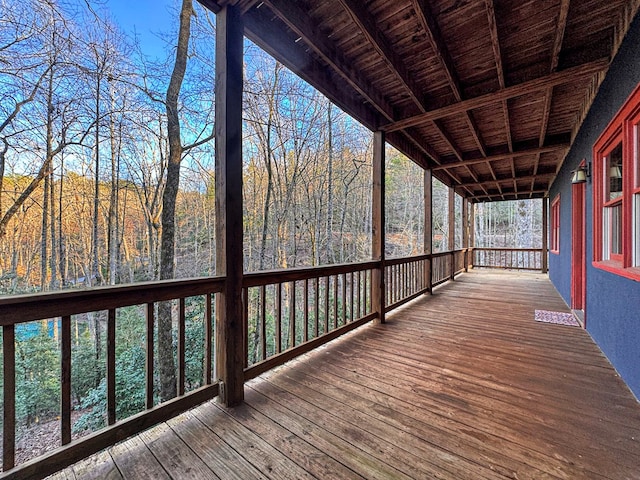 wooden terrace featuring a view of trees