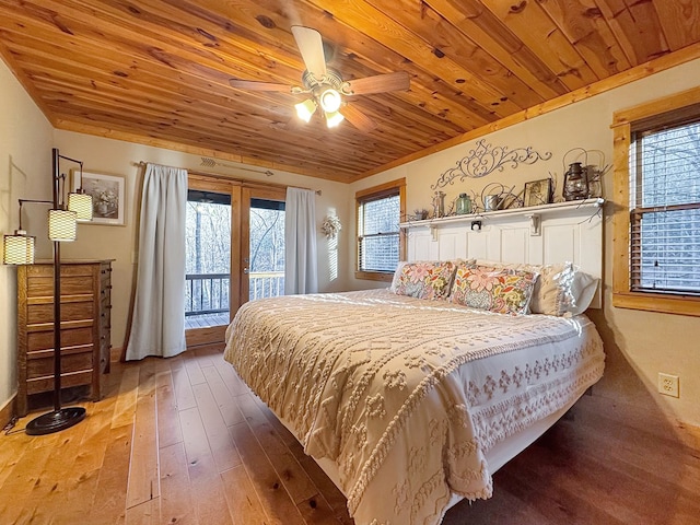 bedroom featuring access to exterior, multiple windows, and wooden ceiling