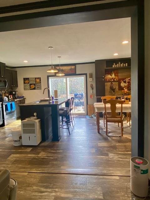 dining room with hardwood / wood-style floors, crown molding, and sink