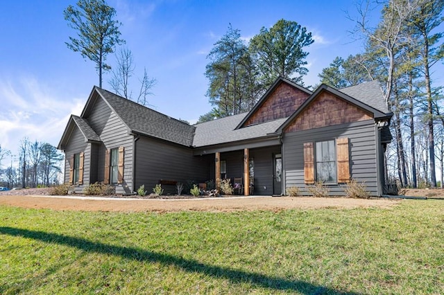 craftsman-style home featuring entry steps, a front lawn, and a shingled roof