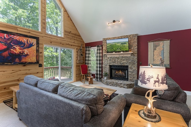 living room featuring a stone fireplace, high vaulted ceiling, and wood walls