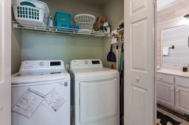 clothes washing area featuring wood walls and washing machine and clothes dryer