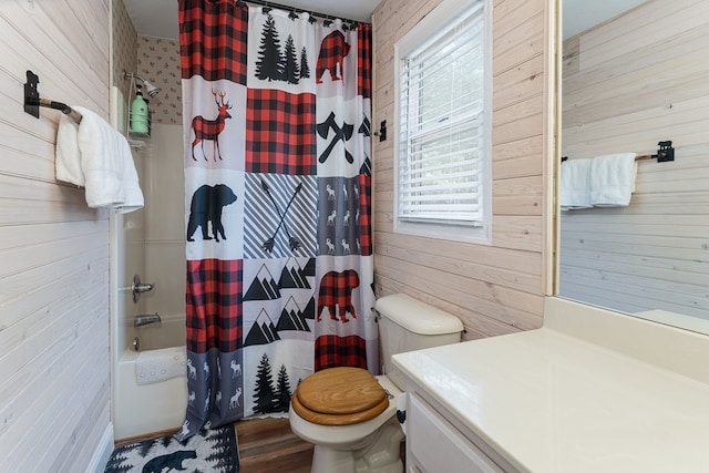 full bathroom featuring wood-type flooring, vanity, wood walls, shower / bath combo, and toilet