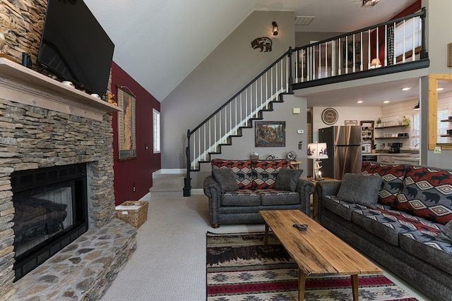 living room featuring high vaulted ceiling, a fireplace, and sink