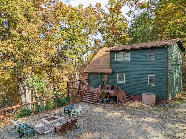 back of house with an outdoor fire pit and a deck