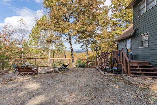 view of yard featuring a deck with mountain view and a fire pit