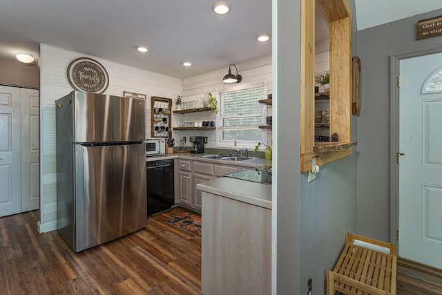 kitchen with a textured ceiling, black appliances, dark wood-type flooring, and sink