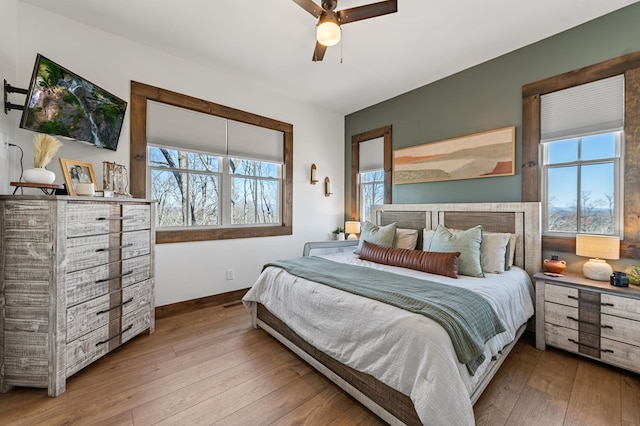 bedroom with ceiling fan, baseboards, and hardwood / wood-style floors