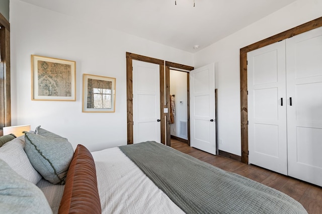 bedroom with a closet, visible vents, and wood finished floors