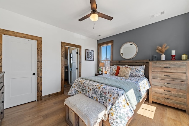 bedroom featuring visible vents, baseboards, wood finished floors, and a ceiling fan