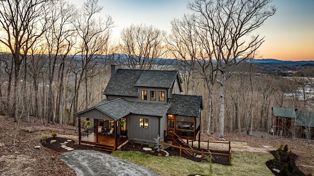 view of front of property with a chimney and a shingled roof