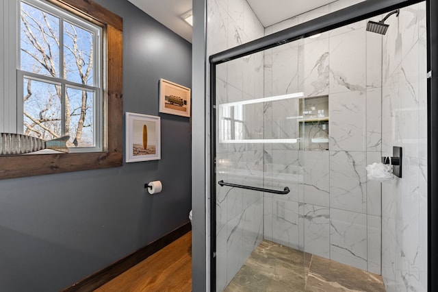 bathroom featuring a marble finish shower and toilet