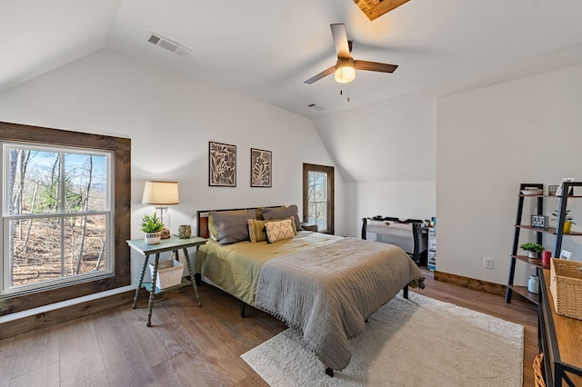 bedroom featuring vaulted ceiling, multiple windows, and wood finished floors