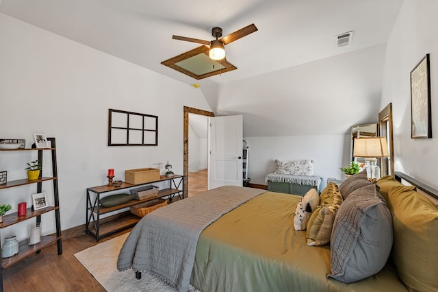 bedroom featuring visible vents, baseboards, lofted ceiling, wood finished floors, and a ceiling fan