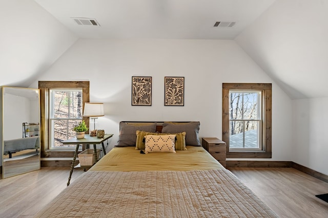 bedroom featuring visible vents, lofted ceiling, and wood finished floors