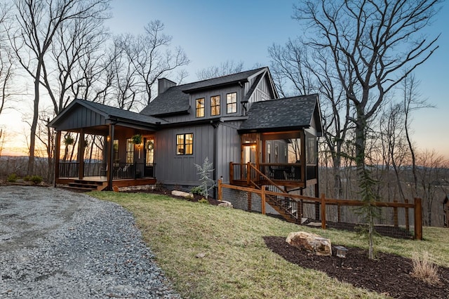 exterior space featuring a front lawn, a porch, board and batten siding, a shingled roof, and a chimney