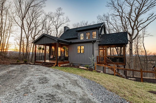 rear view of house featuring a lawn, a porch, fence, roof with shingles, and a chimney