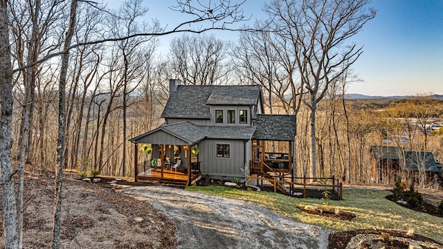 view of front of house featuring roof with shingles and a chimney