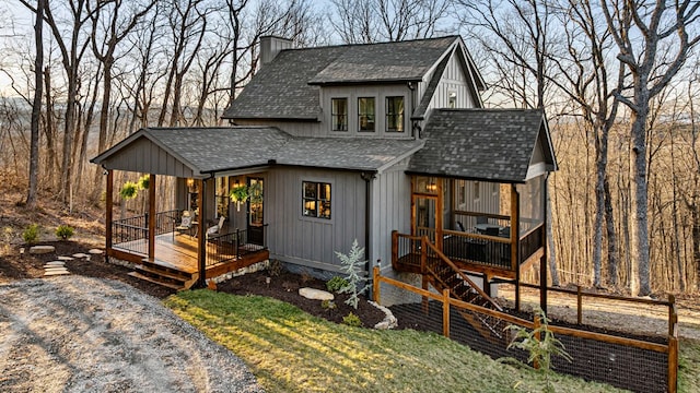 exterior space with a chimney, roof with shingles, and fence